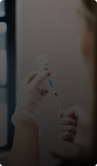 Person holding syringe preparing for self-injection or medical treatment at home