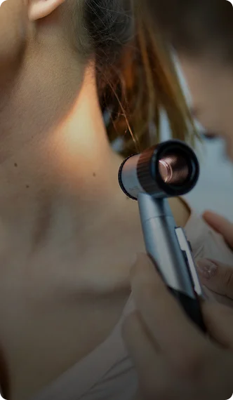 Woman using flat iron to straighten brown hair close-up view of styling tool and hair strand