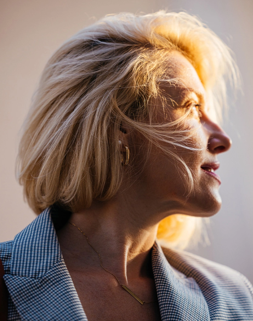 Senior woman with white blonde hair in profile view showing confident expression and natural aging